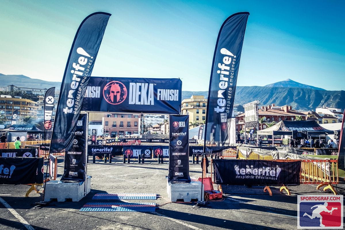 DEKA race finish line in Tenerife with flags and mountains in the background.