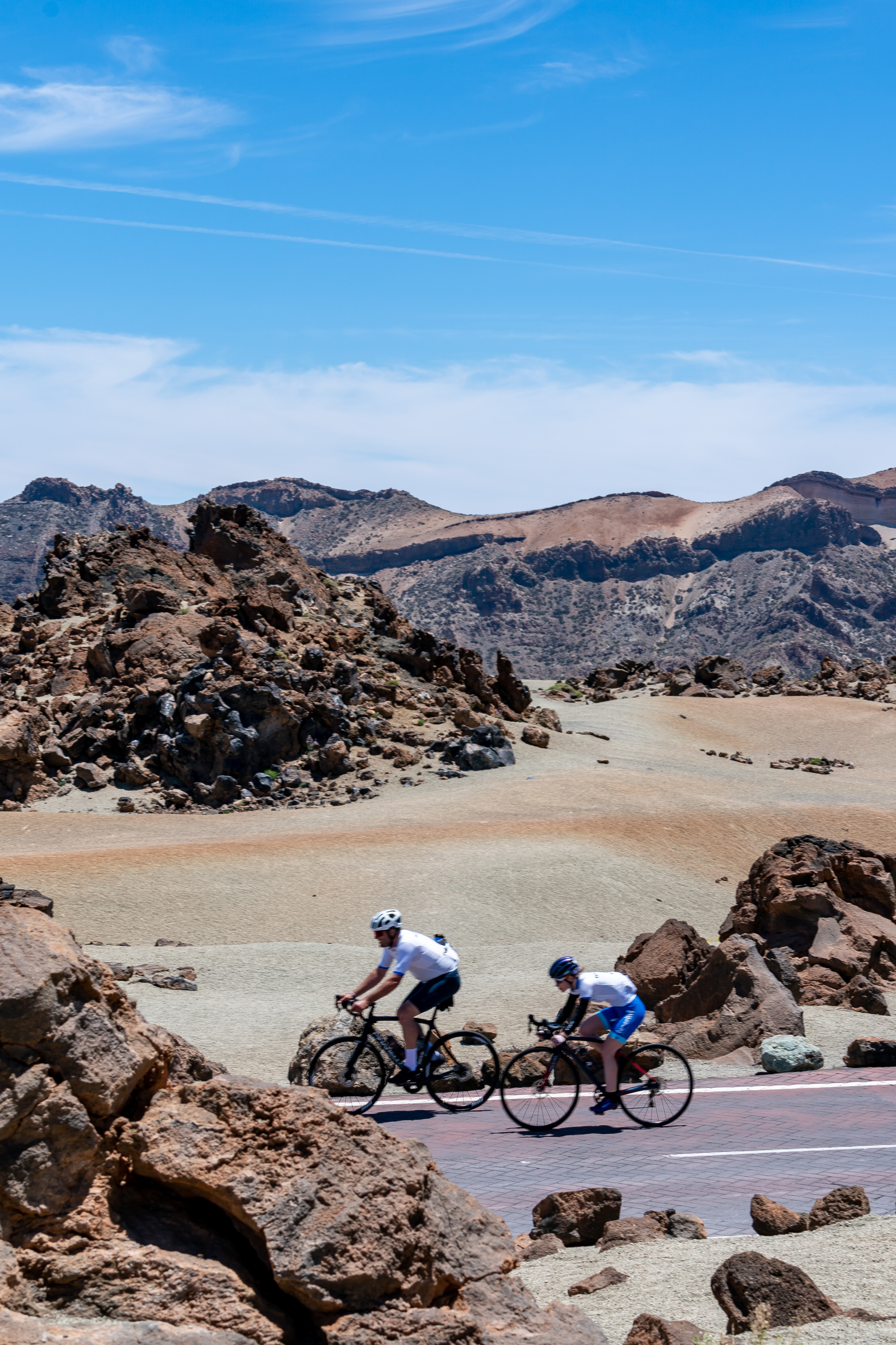 Cyclists riding through the volcanic landscape in Teide National Park, Tenerife.