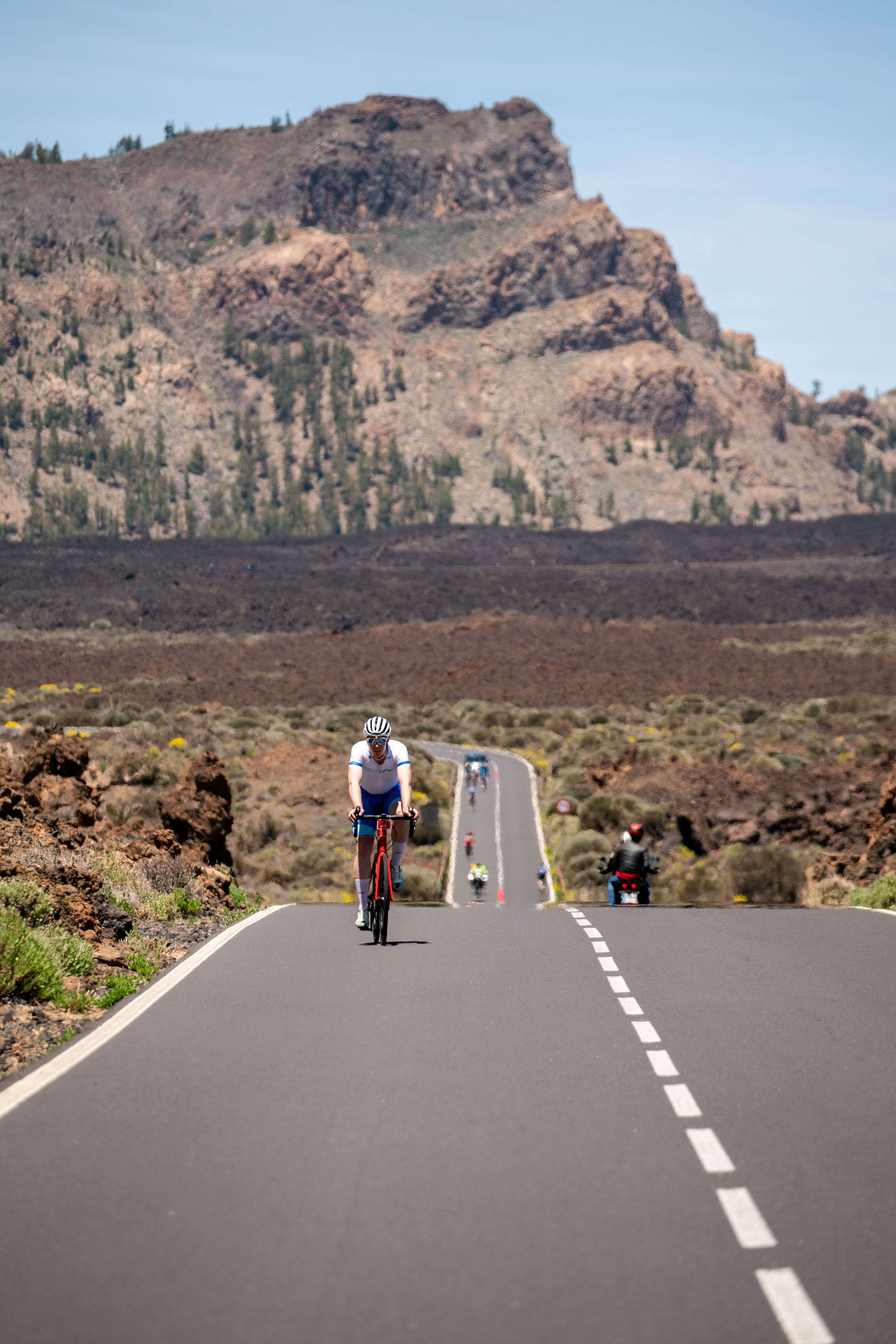 Cyclist on the road to Mount Teide in Tenerife, surrounded by volcanic landscape.