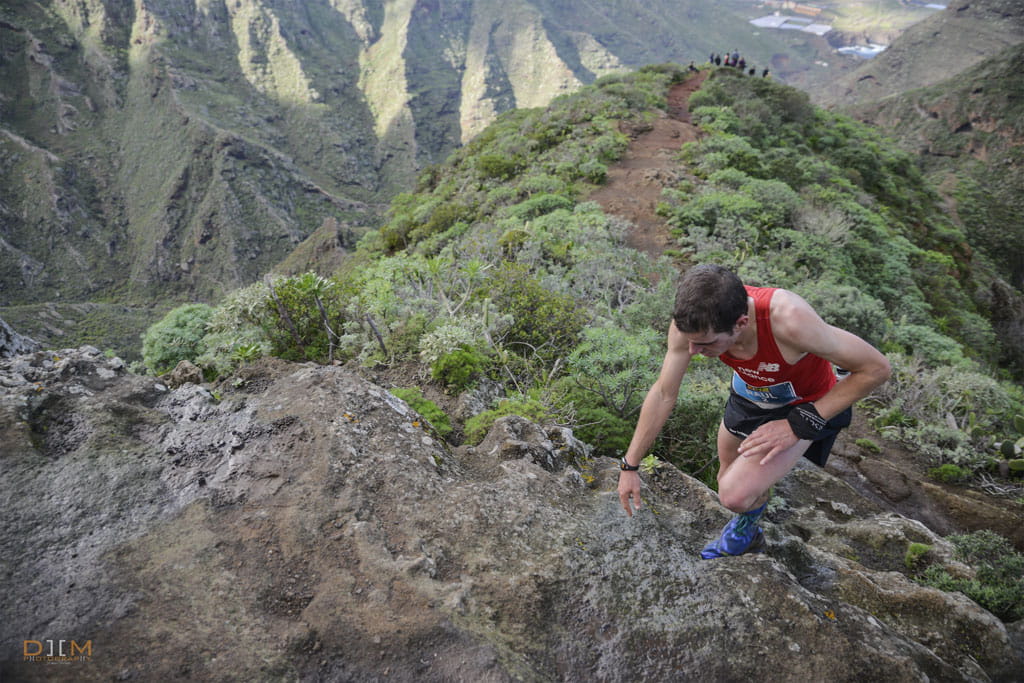 Runner climbing hill on mountain trail in Anaga, Tenerife.
