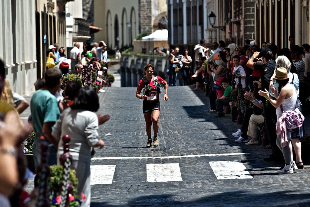 Street marathon runner in La Laguna, Tenerife, surrounded by spectators.