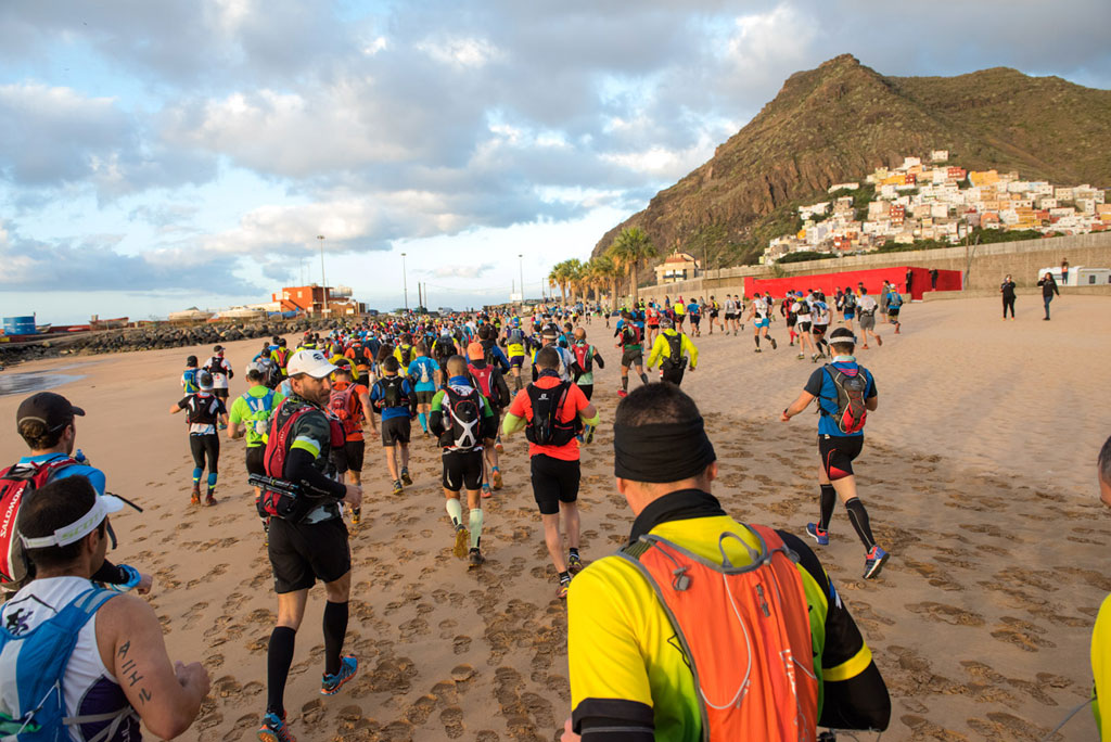 Runners on Las Teresitas beach in Tenerife during a sporting event.