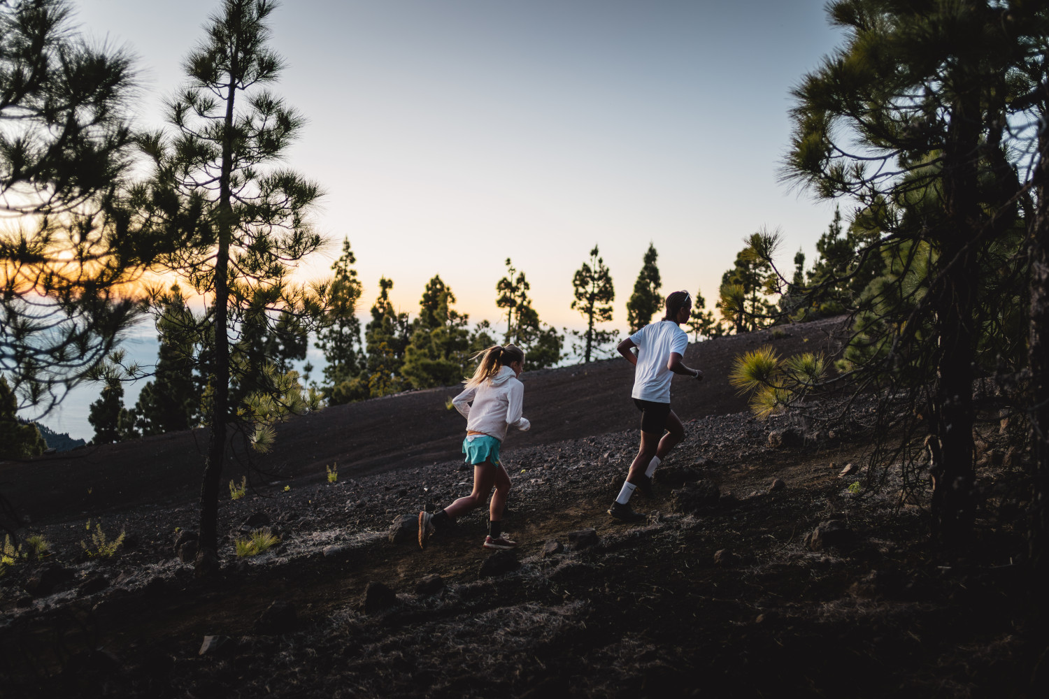 People running at dawn on a mountainous trail in Tenerife.