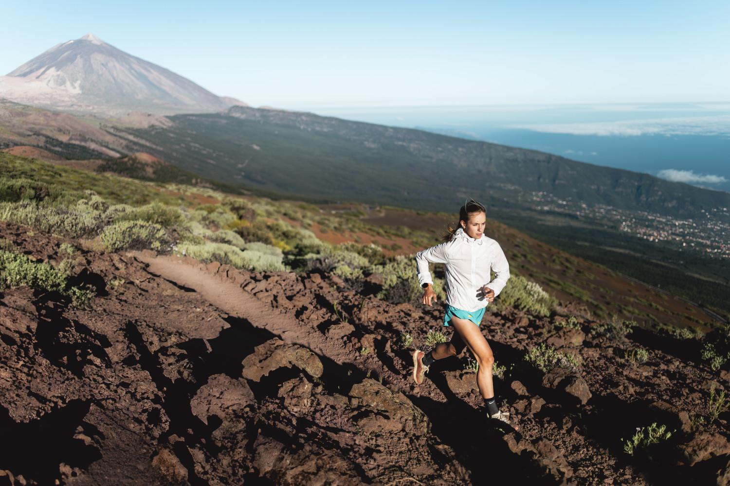 Person running on trail near Mount Teide, Tenerife, overlooking the landscape.