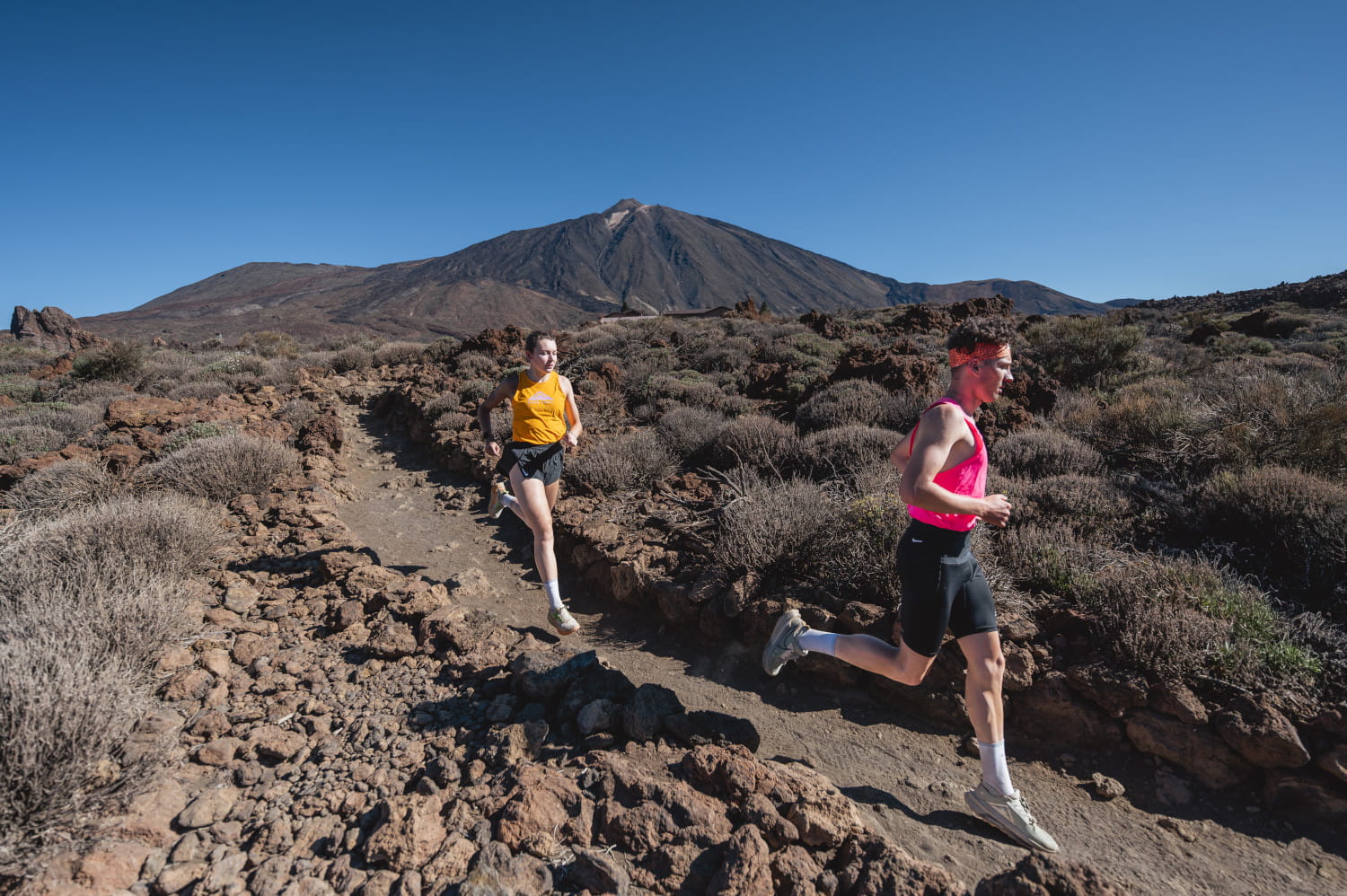 Runners on the path of Teide, Tenerife, with the volcano in the background.