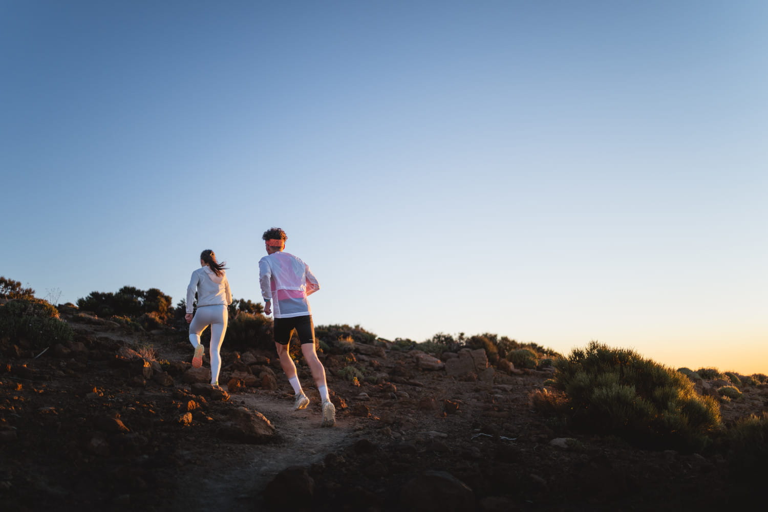 Two people run at dawn along a path in Tenerife.