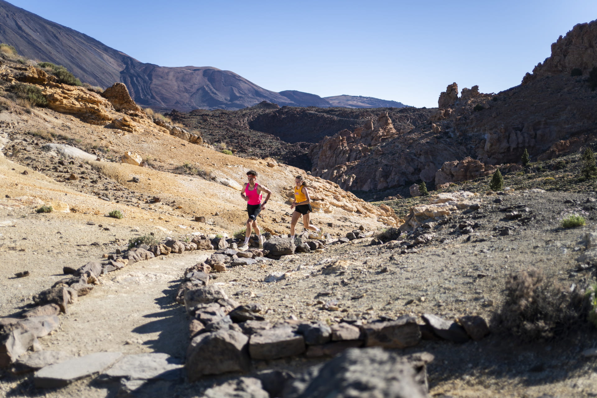 Two people running on a trail in Teide National Park, Tenerife.