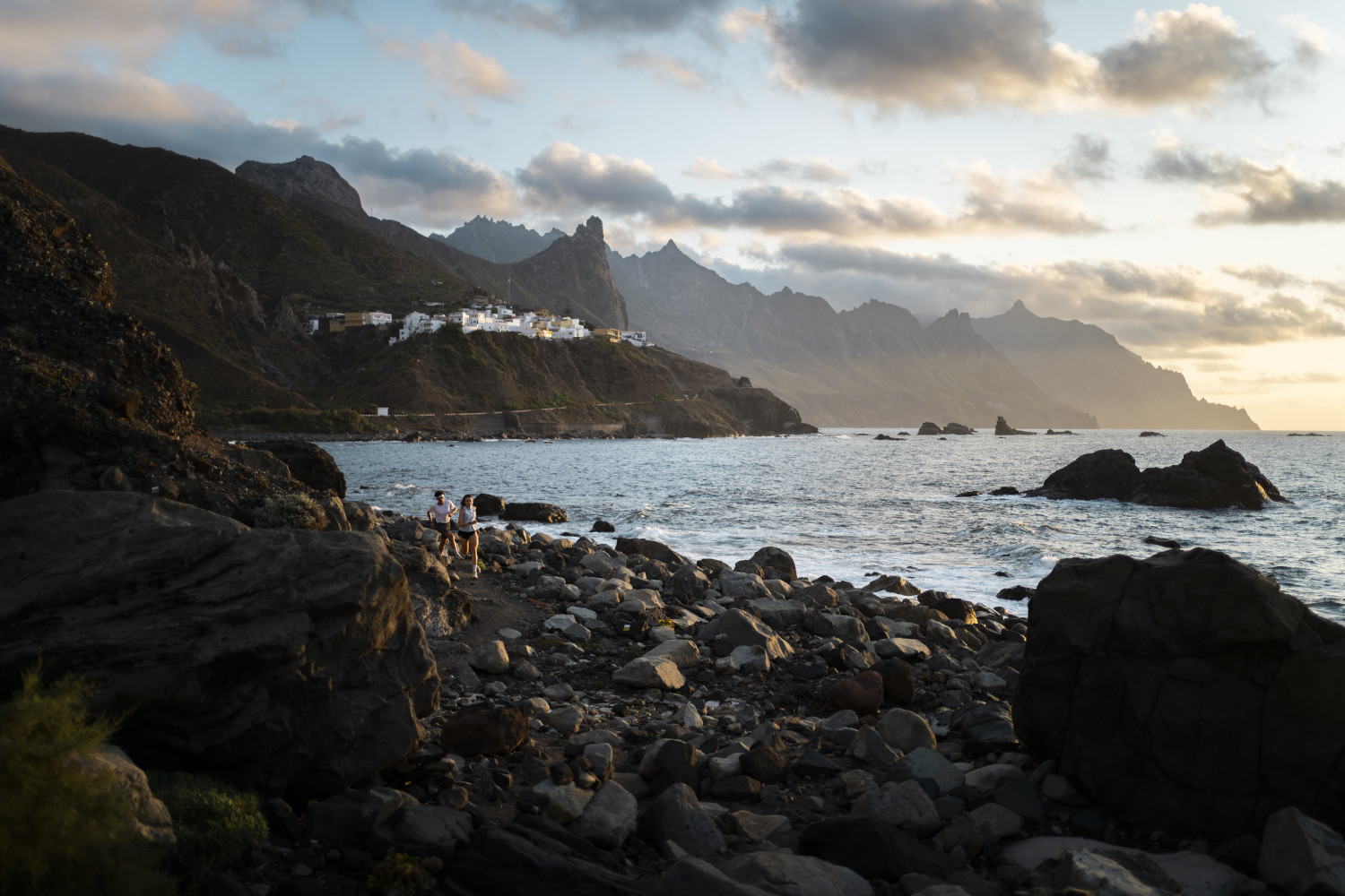 Rocky coast of Benijo in Tenerife with mountains at sunset.