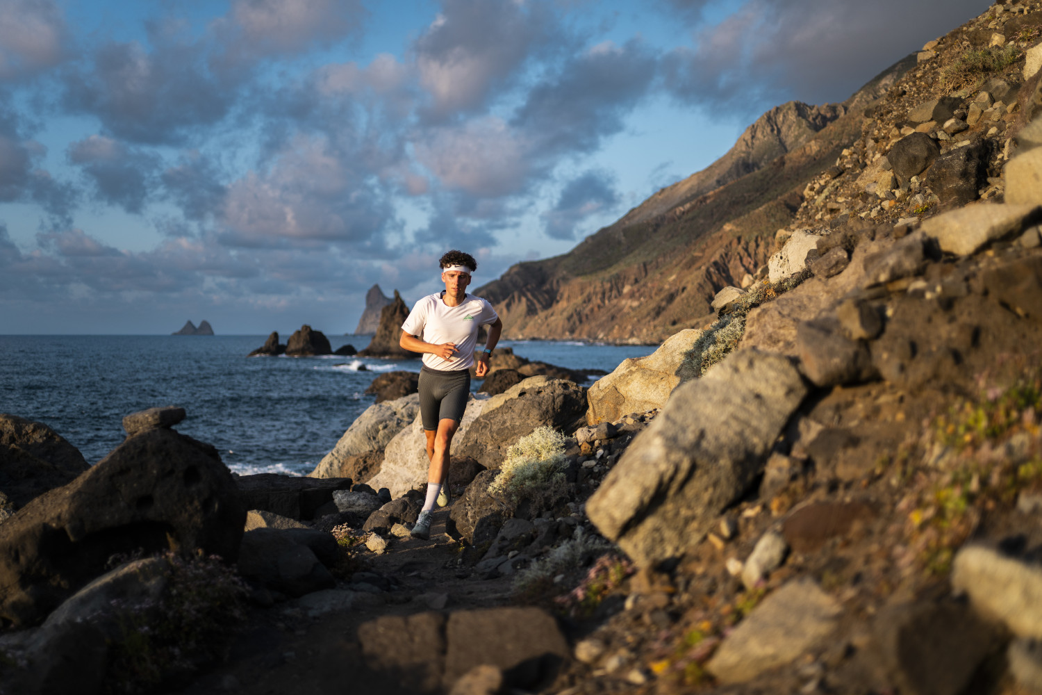 Person running along a rocky coast in Tenerife in front of the sea.