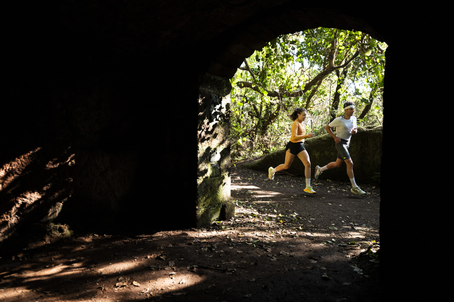 Two people running along a wooded path in Tenerife.