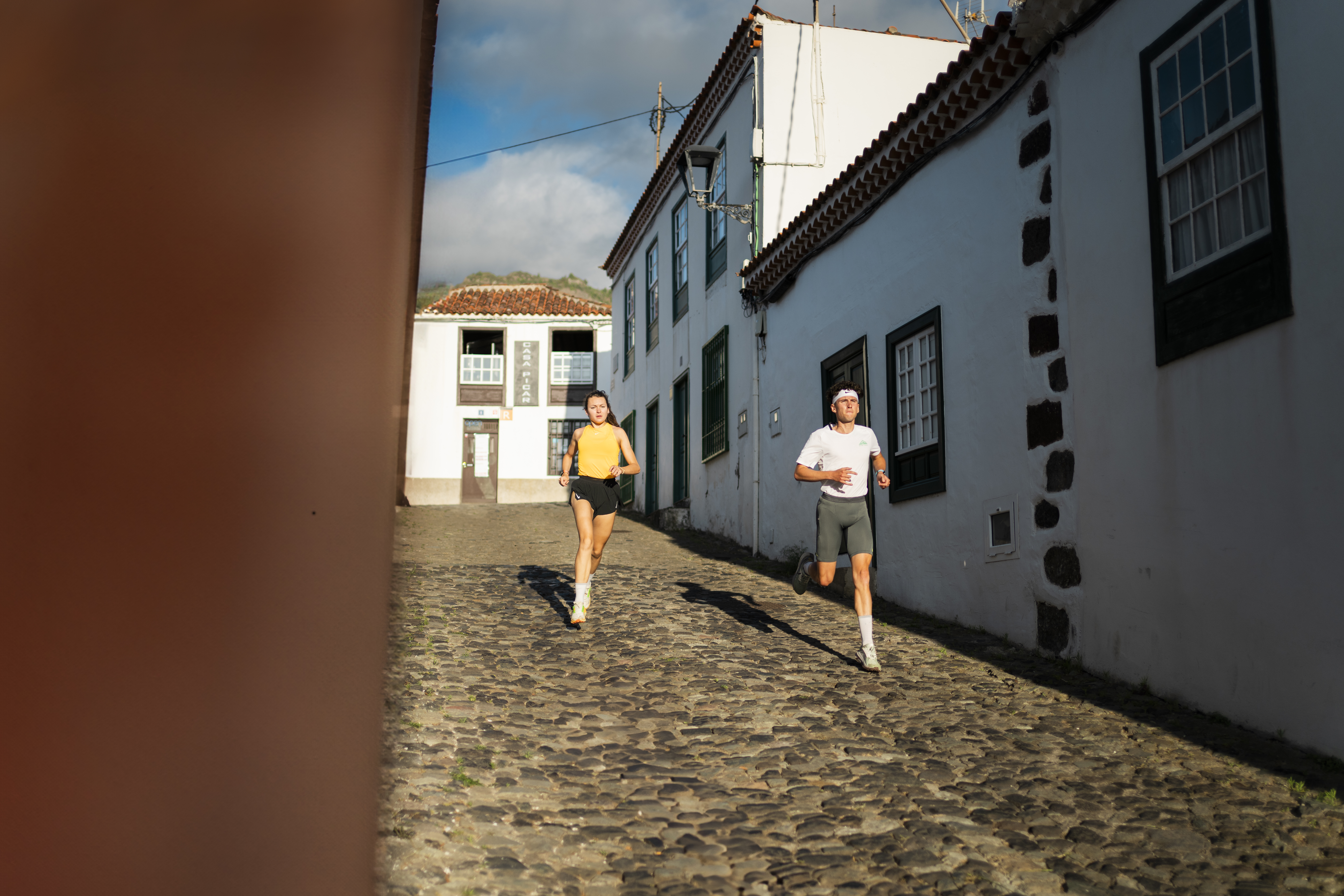 People running on a cobbled street in Tenerife.