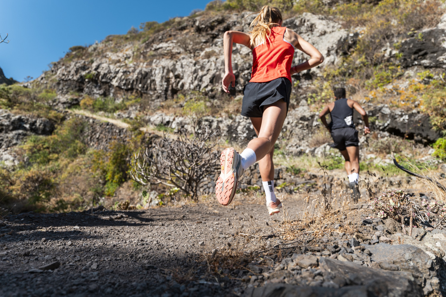 Runners climbing a rocky hill in Tenerife.