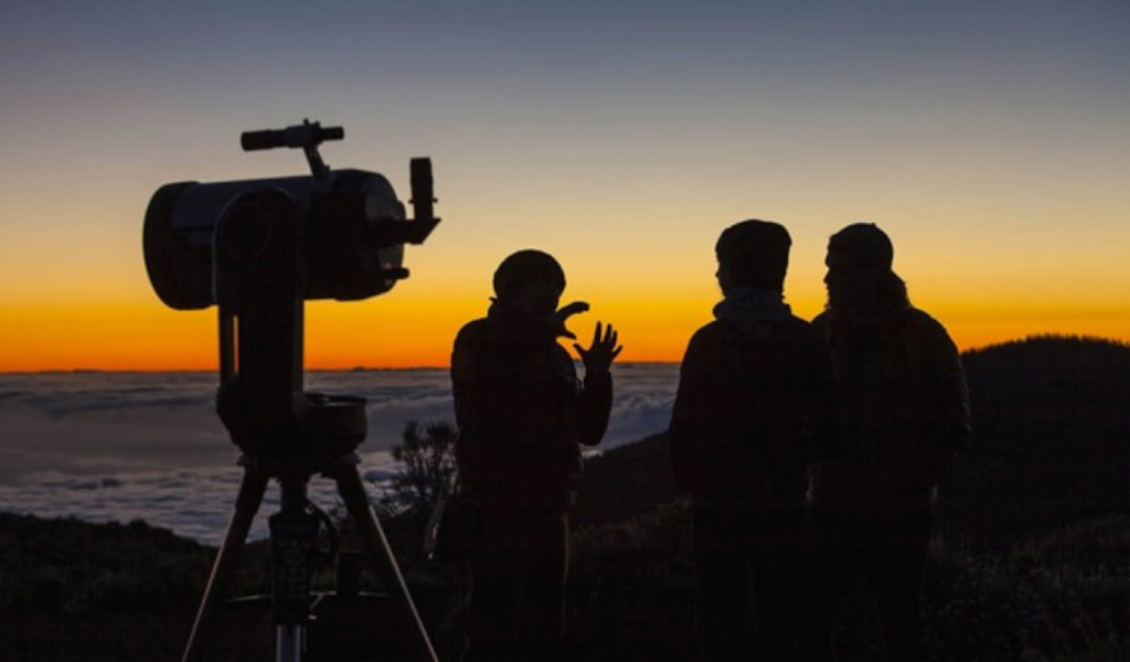 People watching the sunrise with a telescope in Tenerife.