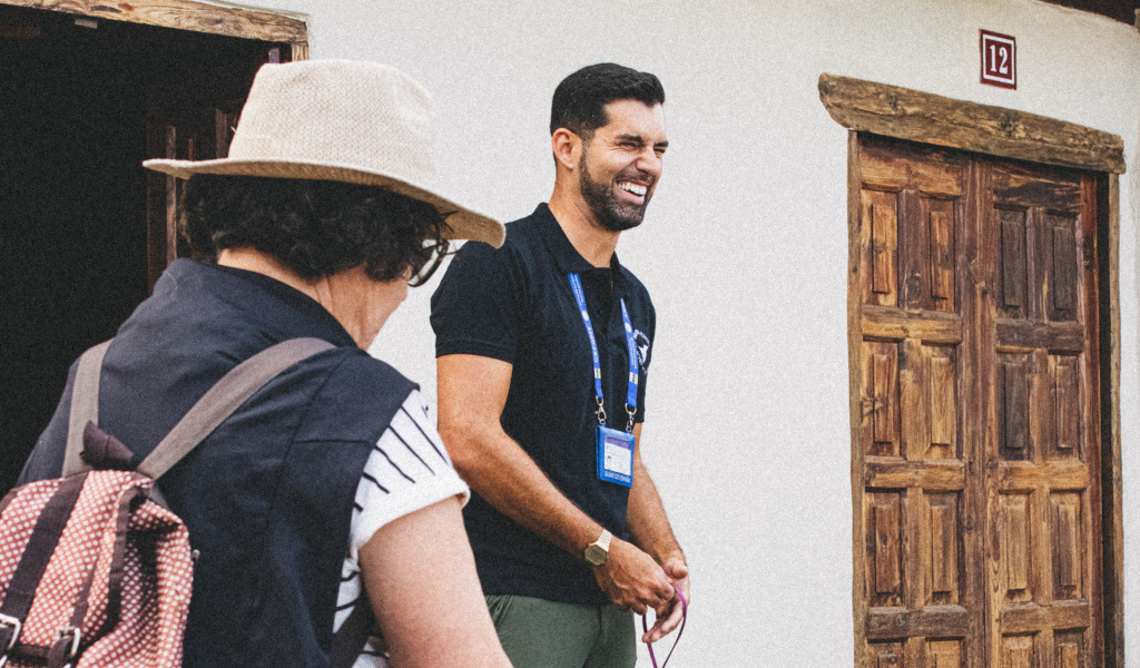 Person in black T-shirt smiles next to wooden door in Tenerife.