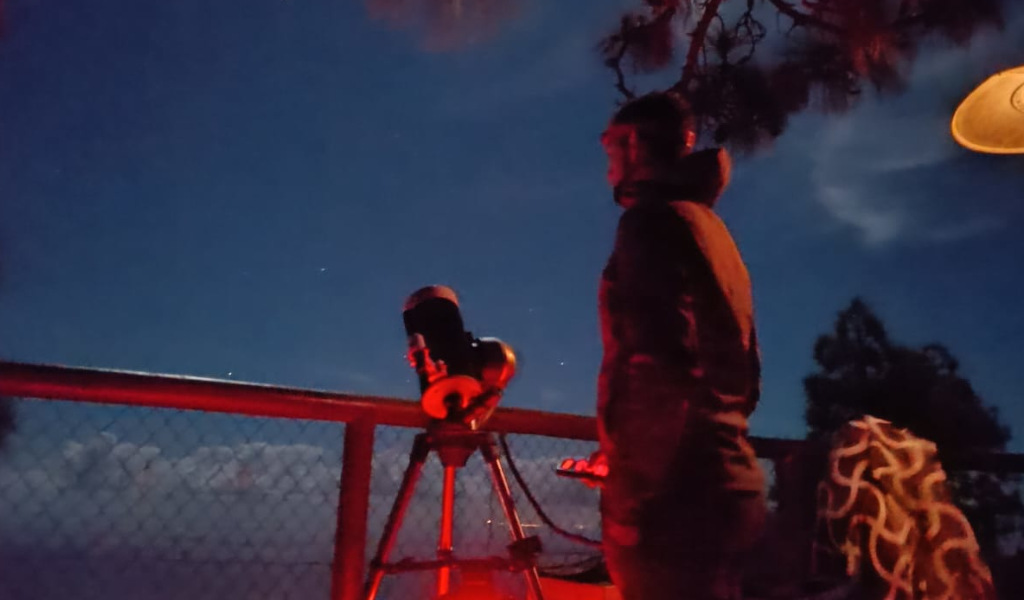 Person observing the night sky with a telescope, possibly in Tenerife.