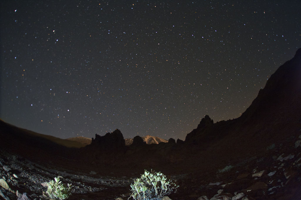 Starry sky over Mount Teide in Tenerife with mountains in the dark.