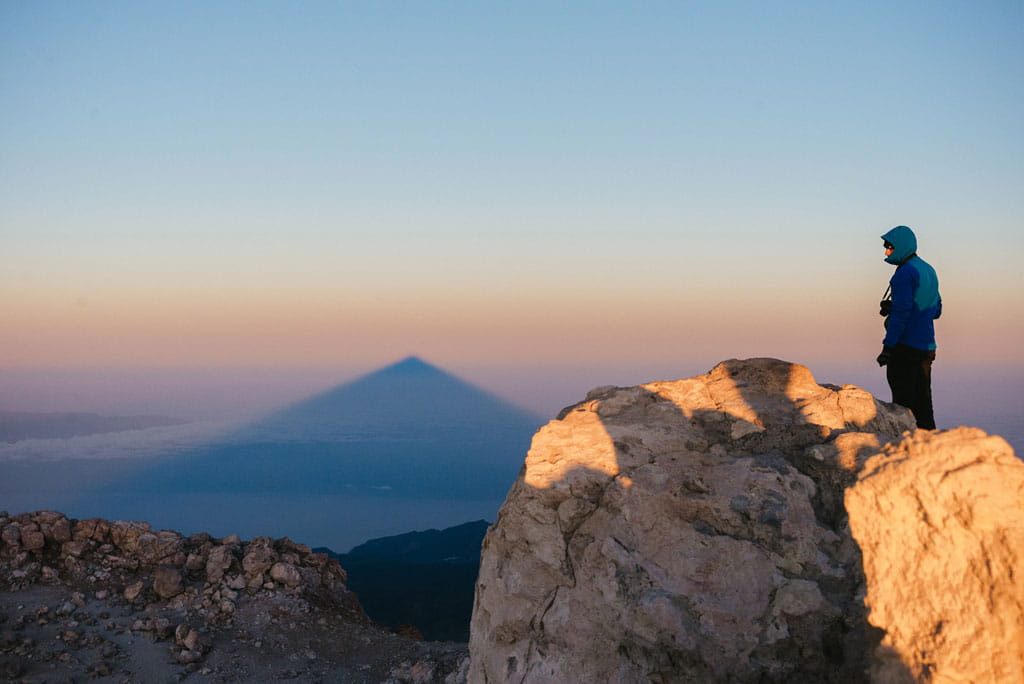 Person observing the shadow of the Pico del Teide at dawn in Tenerife.