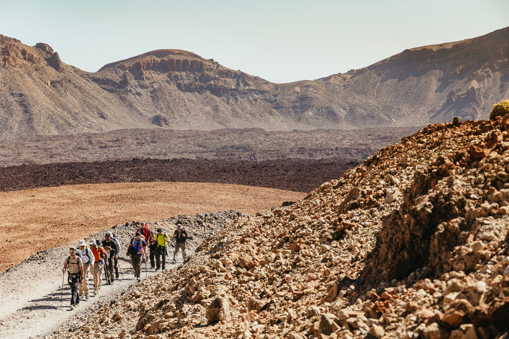 Group of hikers on a rocky path in Teide National Park, Tenerife.