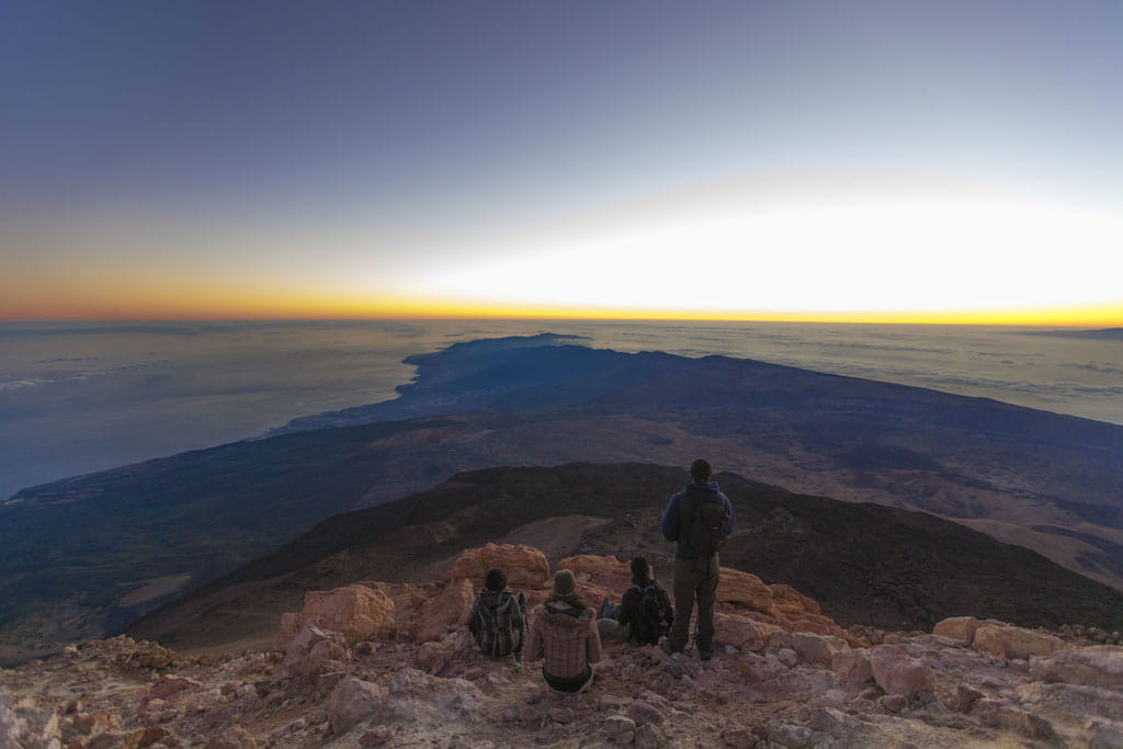 Sunrise on Mount Teide, Tenerife, with people watching the landscape from the top.