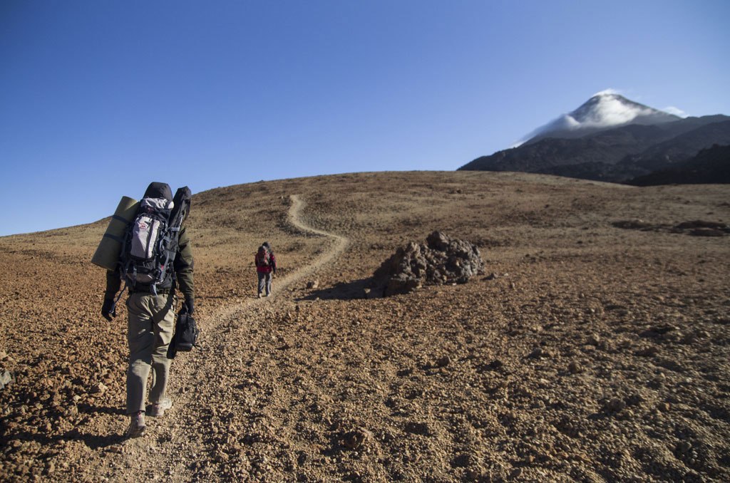 Trail to Mount Teide in Tenerife with two hikers walking.