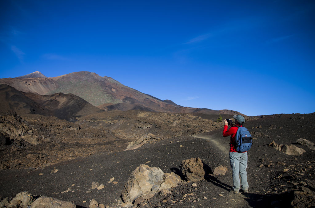 Person photographing volcanic landscape in Teide National Park, Tenerife.