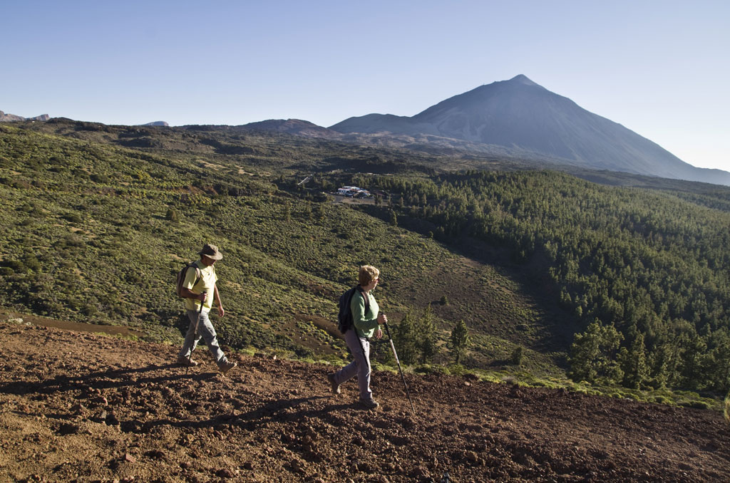 Hikers in the Teide National Park, Tenerife, with a volcano background.