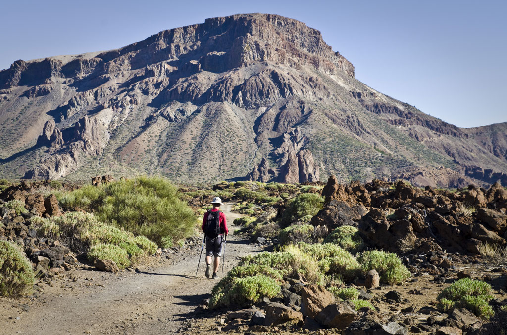 Hiker walking along the path at the foot of Mount Teide in Tenerife.