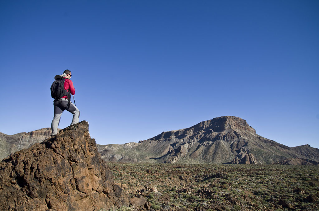 Hiker with a backpack on a rocky mountain in the Teide National Park, Tenerife.