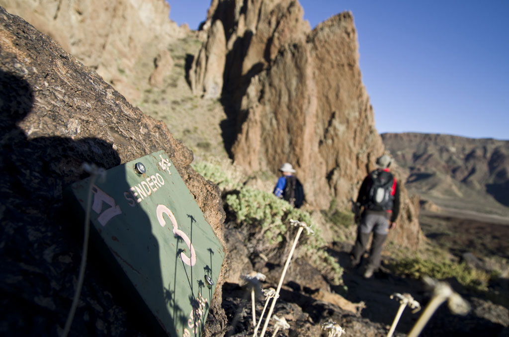 Trail 3 in Tenerife with two hikers walking near rock formations.