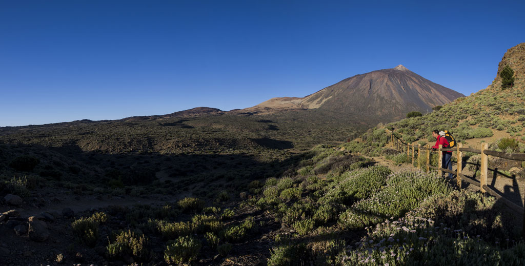 Trail with mountaineer and view of Mount Teide in Tenerife.