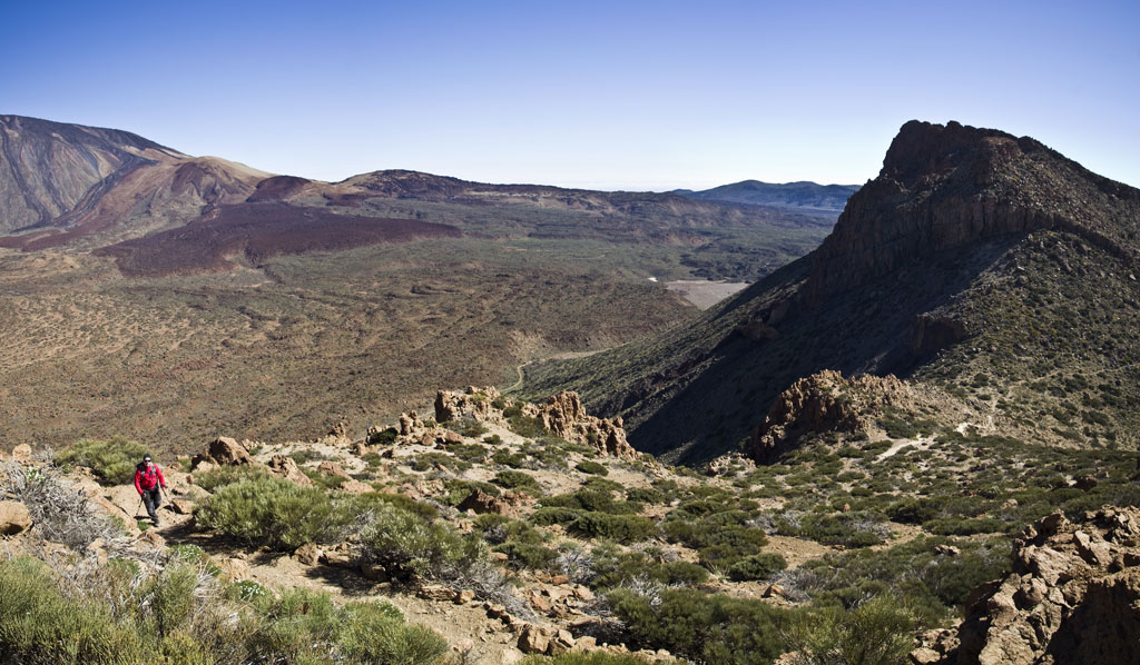 Person walking in the volcanic landscape of Teide National Park, Tenerife.