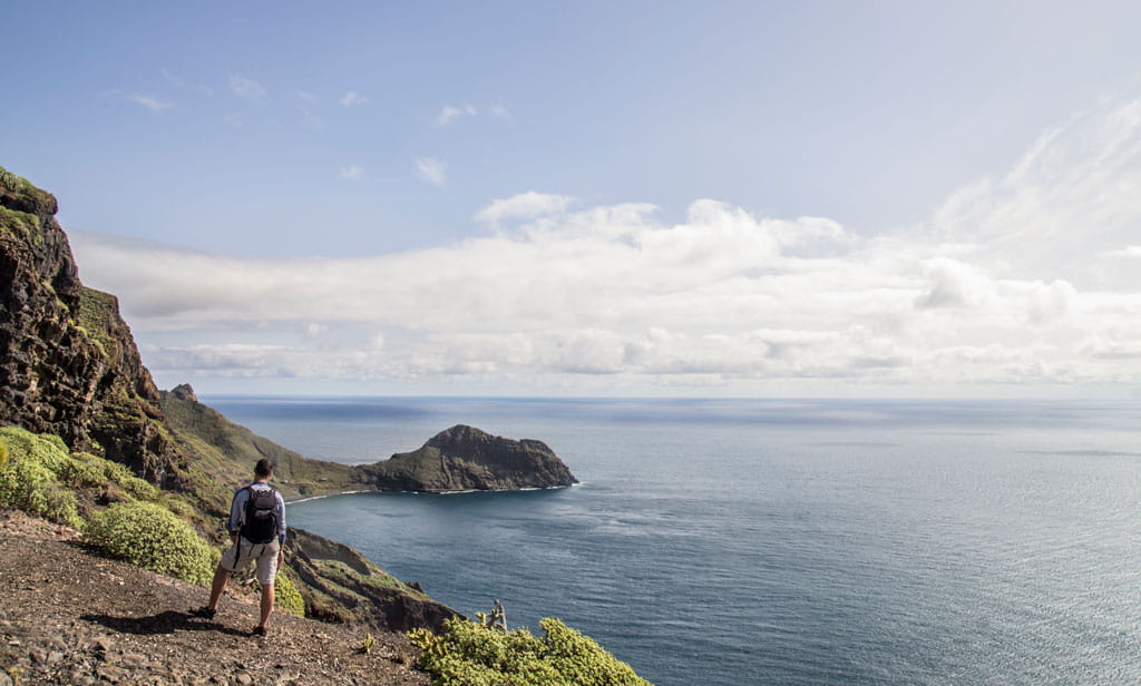 Hiker on a cliff overlooking the sea in Tenerife.