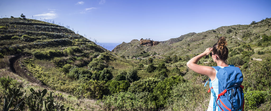 Person with backpack observes mountainous landscape in Tenerife.
