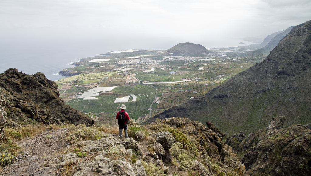 Hiker observes panoramic view from the cliff in Tenerife.