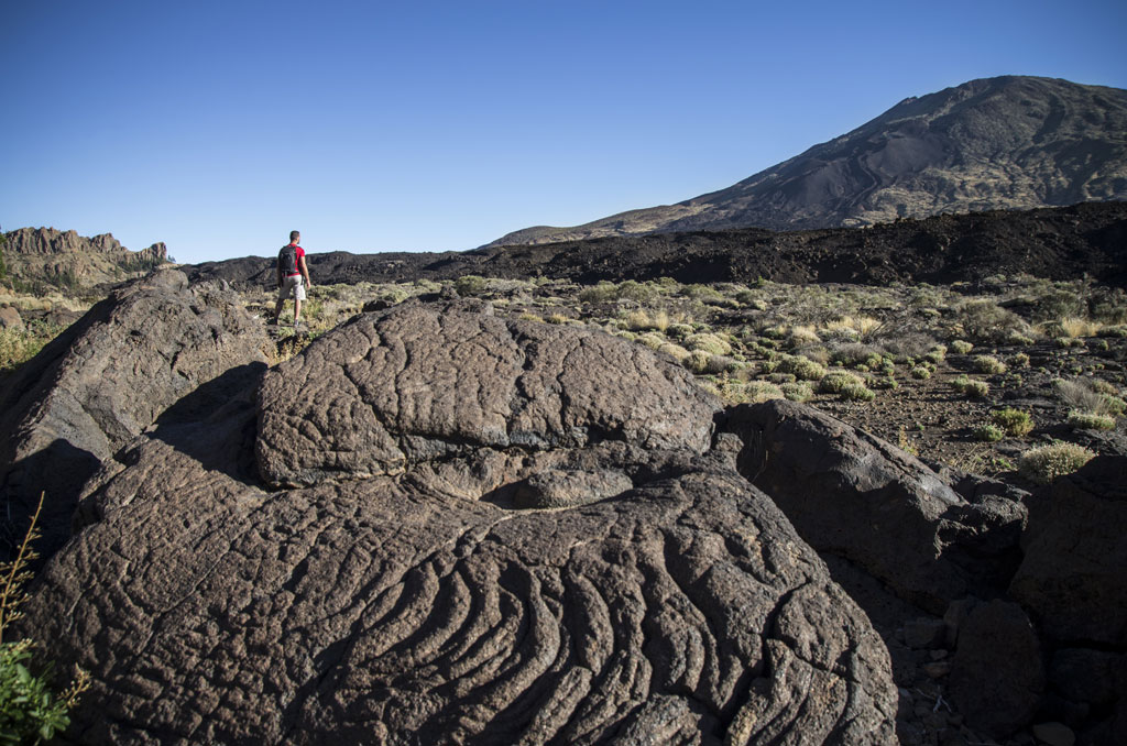 Person walking through the volcanic landscape of Teide in Tenerife.