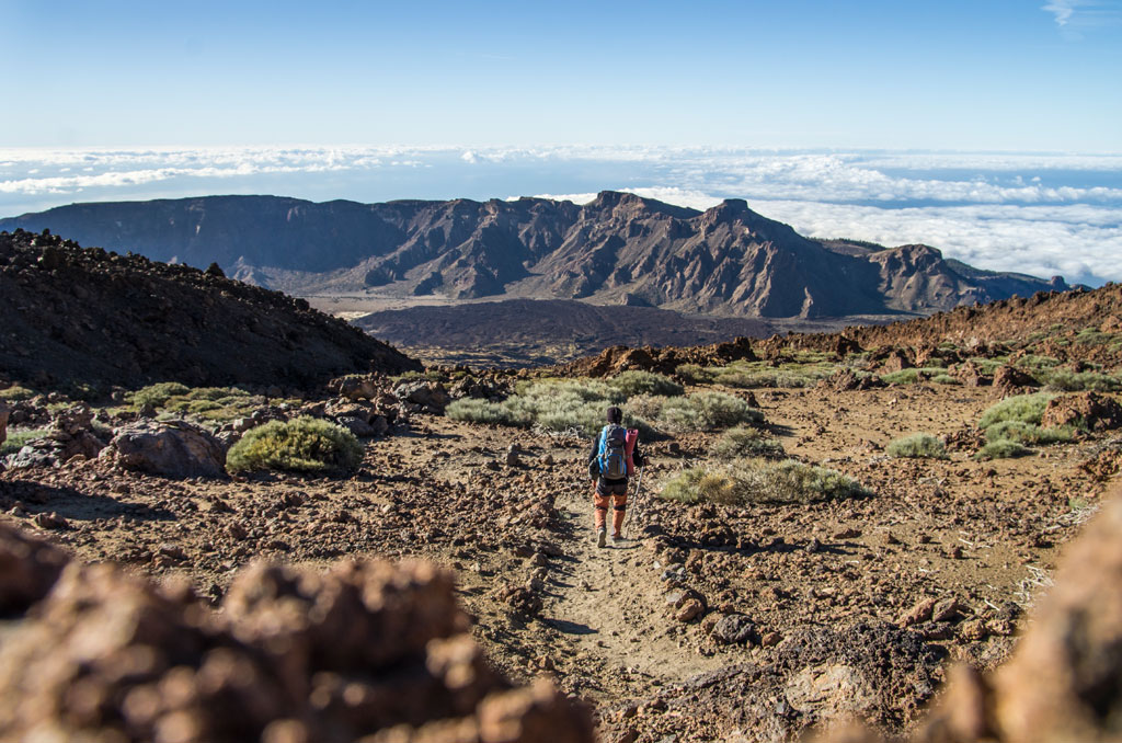 Person walking on a mountainous trail in Teide National Park, Tenerife.