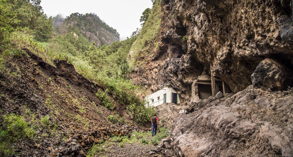 Rocky trail with a hiker near a cave in Anaga, Tenerife.