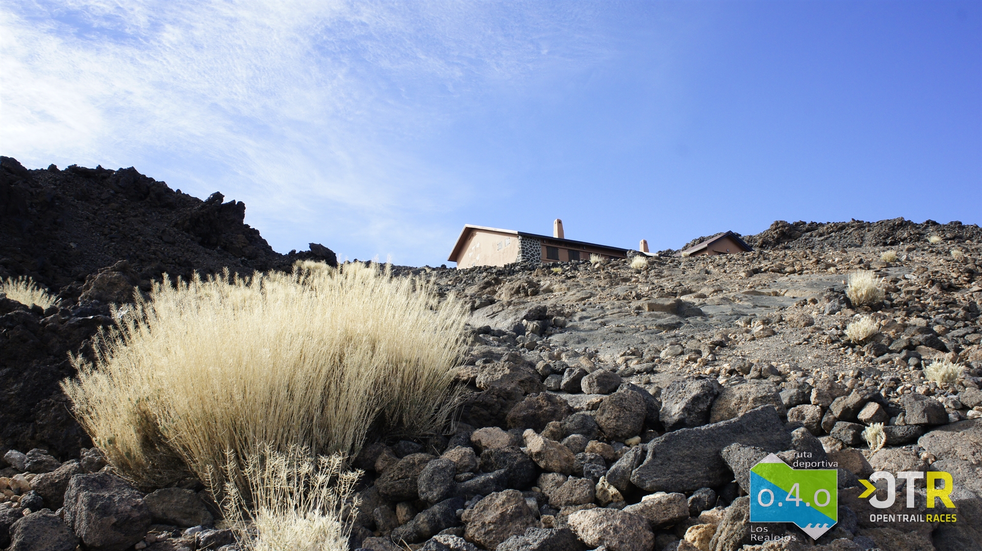 Rocky landscape with building on El Teide, Tenerife, clear sky, OTR logo visible.