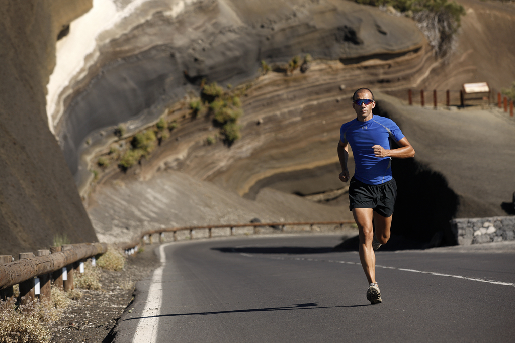 Runner with blue t-shirt on mountain road in Tenerife.