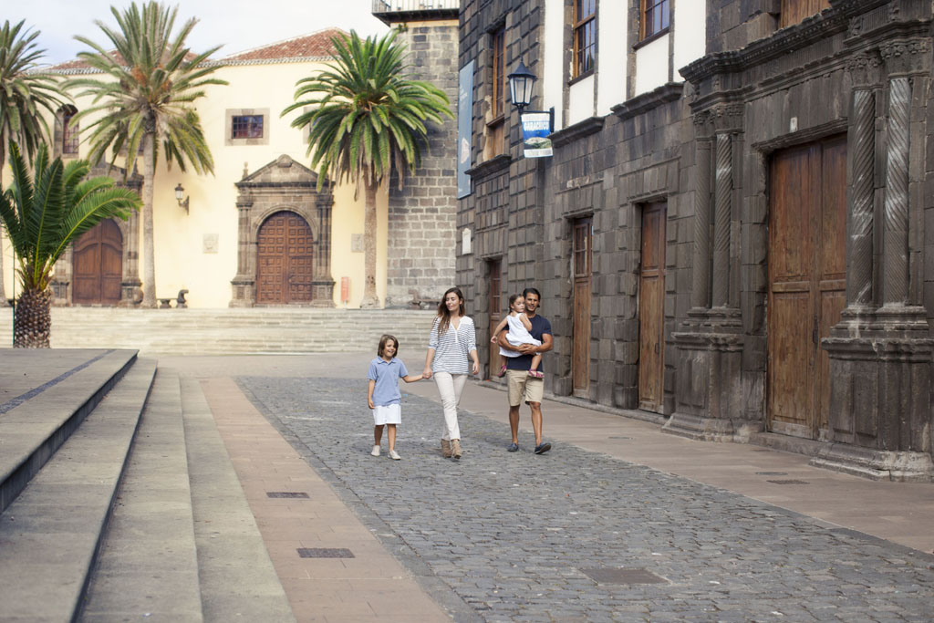 Family walking down the street with historic buildings in La Laguna, Tenerife.