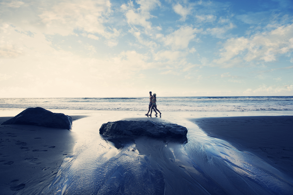 People walking on the beach in Tenerife at sunset.