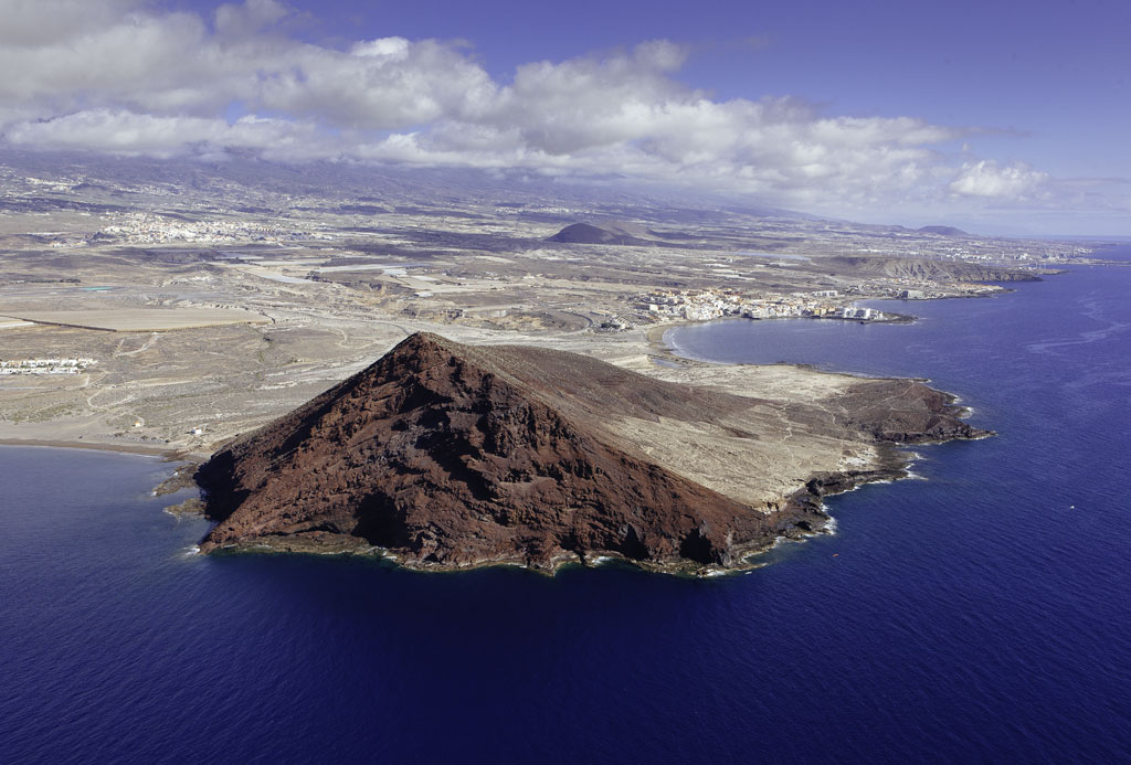 Red Mountain in Tenerife seen from the air next to the Atlantic Ocean.
