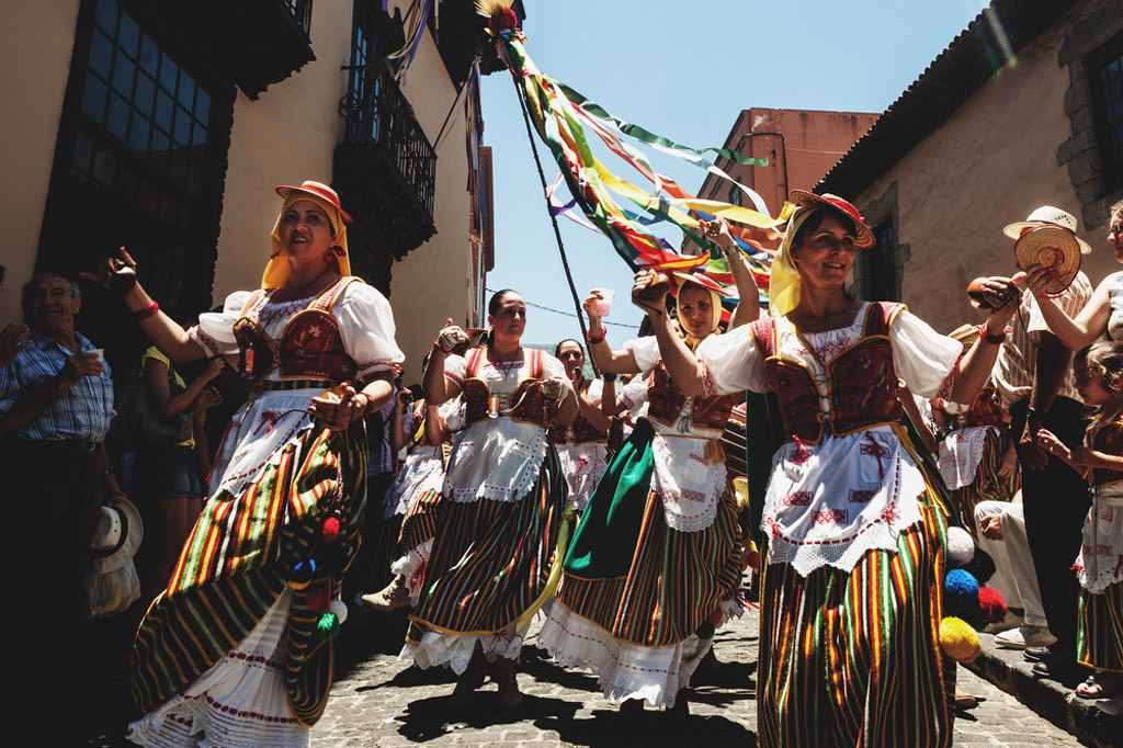 People in traditional dresses dance on a street in Tenerife.