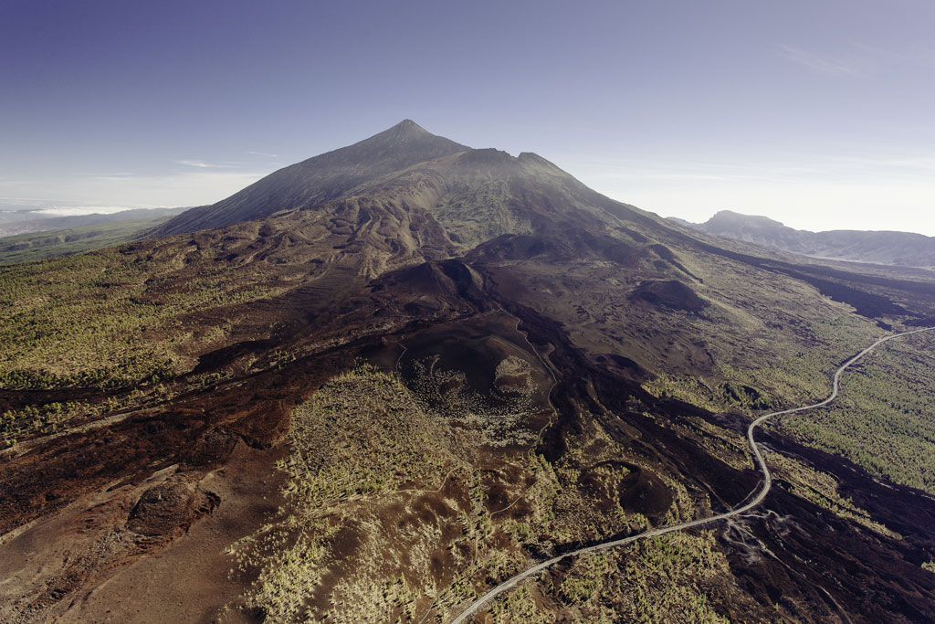 Aerial view of Mount Teide in Tenerife with a volcanic landscape and a road.