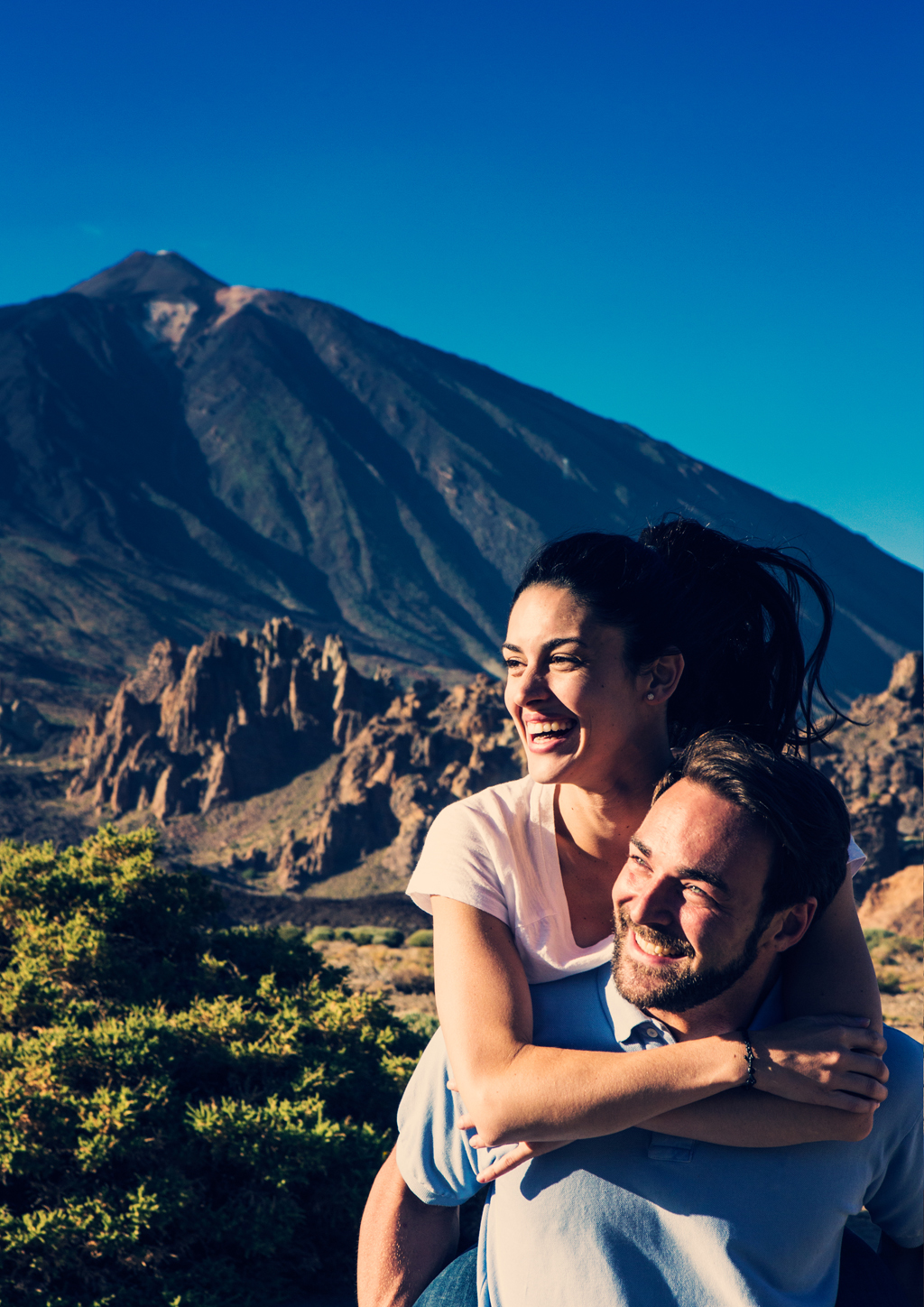 Couple smiling with Mount Teide in Tenerife in the background.