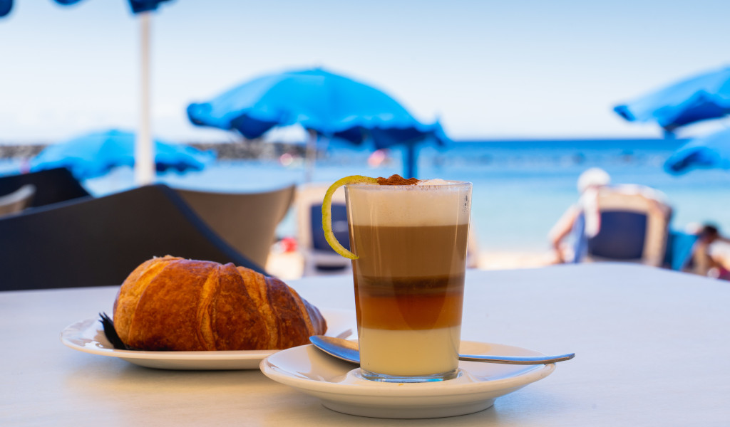 Barraquito coffee and croissant by the sea in Tenerife.