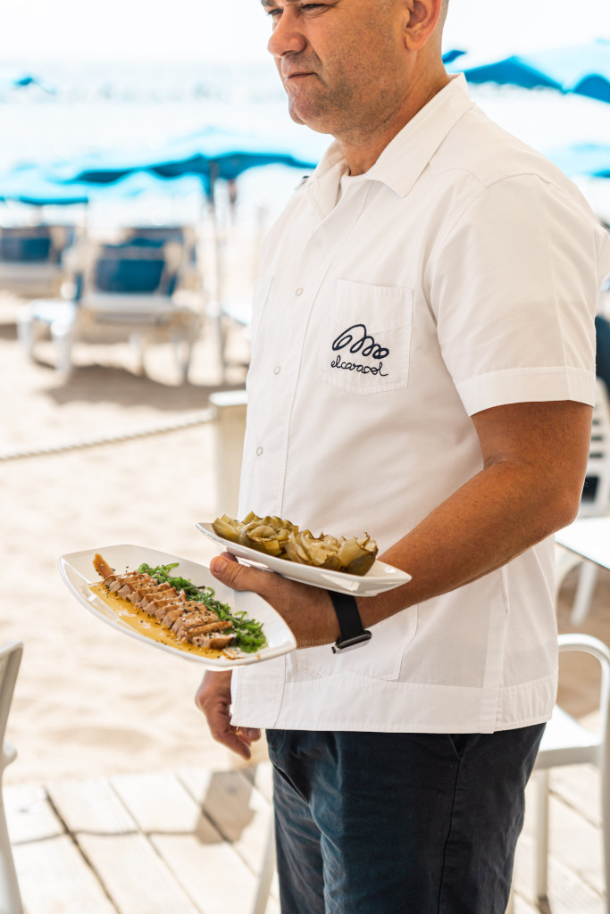 Person serving plates of food on a beach in Tenerife.