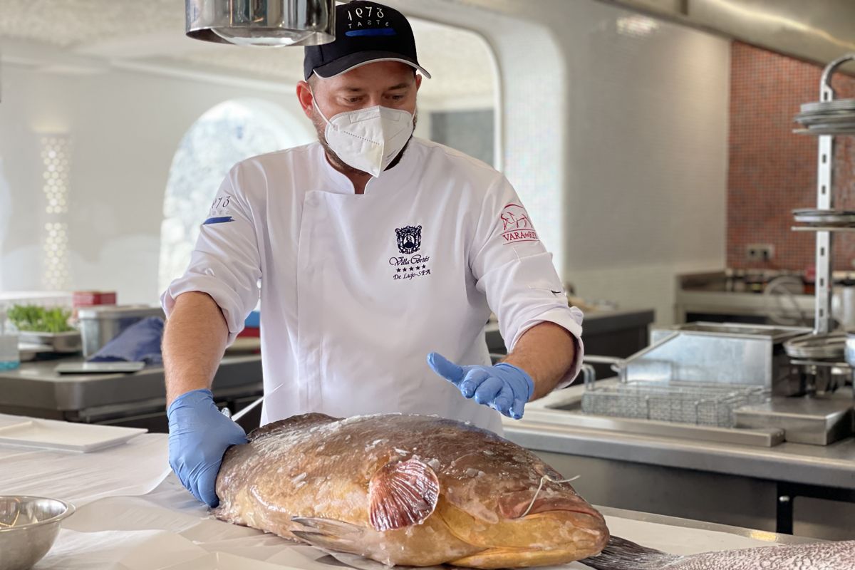 Chef in Tenerife preparing fresh fish in the kitchen.