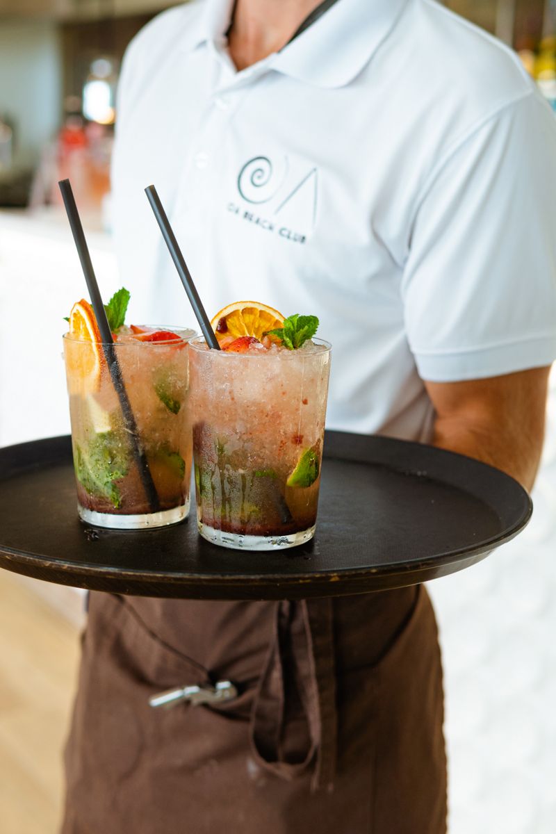 Two cocktails with orange slices on a tray in Tenerife café.