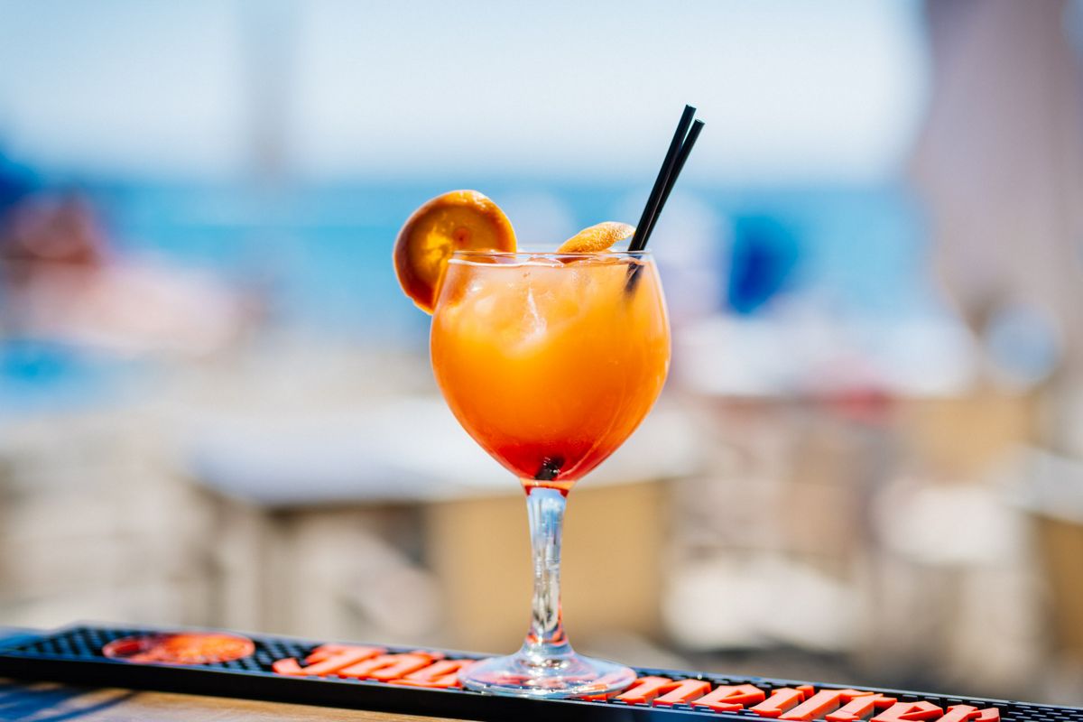 Cocktail with orange slice and two black straws in a bar in Tenerife.